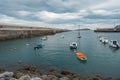 Small boats at the entrance of the fishing port of Bermeo on the coast of Vizcaya on a cloudy day