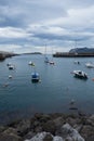 Small boats at the entrance of the fishing port of Bermeo on the coast of Vizcaya on a cloudy day