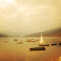 Small boats on the lake - vintage effect. Colorful retro photo. Royalty Free Stock Photo