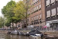 Small boats moored at the side of an urban canal quayside