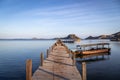 Small boats moored to a small jetty in Komodo Nature Reserve at sunrise.