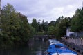 Small boats with raincovers in canal with tree and water reflection for fishing and sailing