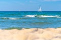 Small boats with sails in the distance on turquoise waters of Baltic sea. Hel, Poland, Europe. Sport and recreation by Royalty Free Stock Photo