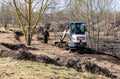 Small bobcat excavator in the park digging for land