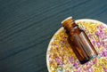 Small bottle with essential oil on the plate with colorful dry herbs and flowers. Aromatherapy, spa and herbal medicine concept. Royalty Free Stock Photo