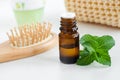 Small bottle with essential peppermint oil. Fresh mint leaves close up. Aromatherapy, spa and herbal medicine ingredients.