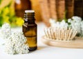 Small bottle with essential yarrow oil, wooden hairbrush and yarrow flowers. Aromatherapy, homemade beauty treatment