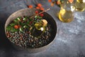 Small bottle of Pistacia terebinthus oil on the bowl of dried seeds on dark wooden background