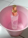 A small bottle of sweet perfume in a pink plastic container