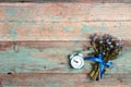 Small bouquet of forget-me-nots flowers with vintage alarm clock on shabby turquoise wooden background