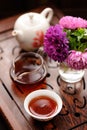 Small bouquet of purple and pink asters and black tea in chinese Royalty Free Stock Photo