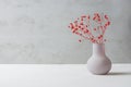 Small Bouquet of Red Flowers in Vintage Vase on White Table Grey Cement Wall Background. Styled Stock Image Mockup for Text Art