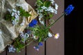 Small bouquet of spring field flowers in a glass jar on wooden rustic background, top view. Selective focus Royalty Free Stock Photo