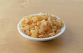 Small bowl filled with diced peaches on a wood table Royalty Free Stock Photo