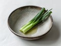 A small bowl filled with vibrant green onions, showcasing the simple beauty of fresh produce Royalty Free Stock Photo