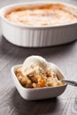 Small bowl of freshly served peach crisp with ice cream