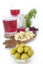 Small bowl with green olives. Nuts and olives, healthy snacks. Appetizer time. Cranberries juice. Mediterranean diet.