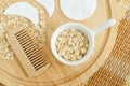 Small bowl with oatmeal and wooden hairbrush. Homemade hair or face mask, natural beauty treatment and spa recipe. Top view Royalty Free Stock Photo