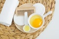 Small bowl with raw egg, small spoon with olive oil and wooden hairbrush. Homemade hair or face mask, natural beauty treatment