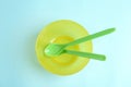 Small bowl and spoons on blue background, top view. Serving baby food