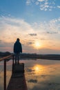 Small boy, child in jacket standing on water gate pond shore at sunset. Czech landscape Royalty Free Stock Photo