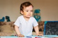 a small boy draws with colorful markers on a piece of paper Royalty Free Stock Photo