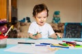 a small boy draws with colorful markers on a piece of paper Royalty Free Stock Photo