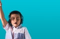 Small boy with expressive face listening to music on headphones dancing and singing authentic unposed image with copy space for