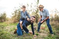 Small boy with father and grandfather in apple orchard in autumn, having fun. Royalty Free Stock Photo