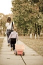 Small boy following Mum with a truck Royalty Free Stock Photo