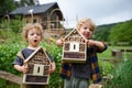 Small boy and girl holding bug and insect hotel in garden, sustainable lifestyle. Royalty Free Stock Photo