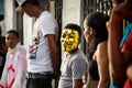Small boy in golden mask looks at camera on city street at dominican carnival
