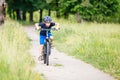 Small boy in helmet riding bicycle in park