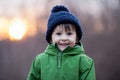 Small boy holds his hands over ears not to hear, making sweet funny face Royalty Free Stock Photo