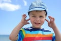 Small boy holds his hands over ears not to hear Royalty Free Stock Photo