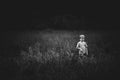 Small boy in the middel of a field in black and white