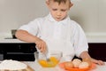 Small boy mixing eggs in a bowl