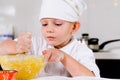 Small boy mixing ingredients for a cake in a bowl