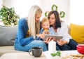 A small boy with mother and grandmother at home at Christmas time, using tablet. Royalty Free Stock Photo