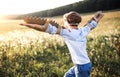 A small boy playing on a meadow in nature, with goggles and wings as if flying. Royalty Free Stock Photo