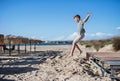 A small boy playing outdoors on sand beach, jumping. Royalty Free Stock Photo