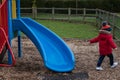 A small boy playing on a slide at the park Royalty Free Stock Photo