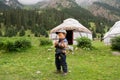 Small boy plays near farmer house Yurt in a valley between the mountains of Central Asia