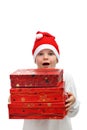 Small boy in Santa red hat carrying three presents