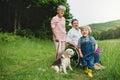 Small boy with senior grandparents and dog on a walk on meadow in nature. Royalty Free Stock Photo