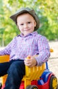 Small boy sitting on a toy truck Royalty Free Stock Photo