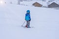 Small boy in ski mask and helmet learns skiing. Mountain alpines landscape in the winter season