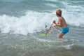 Small boy stands with a fishing-net in the water Royalty Free Stock Photo