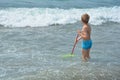 Small boy stands with a fishing-net in the water Royalty Free Stock Photo