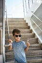 Small boy in sunglasses eating lollipop on white yacht Royalty Free Stock Photo